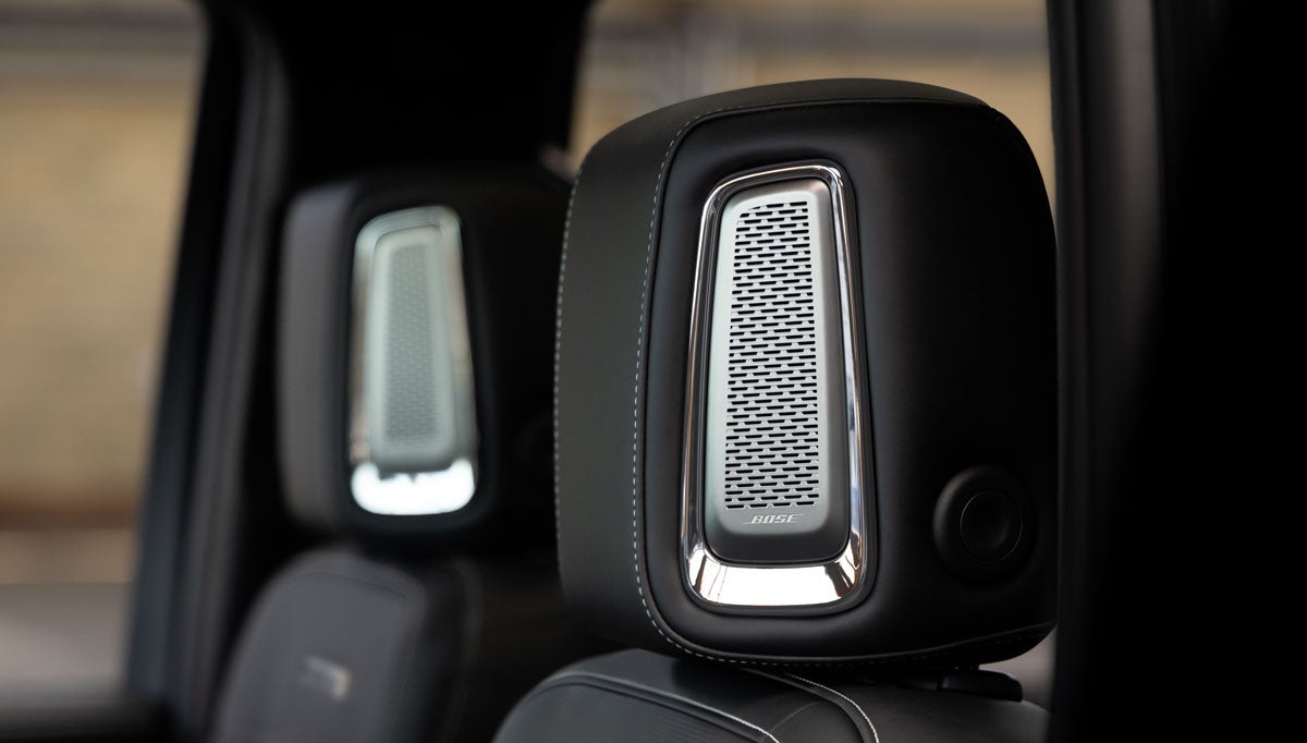 Driver's perspective of a GMC interior, showcasing the steering wheel, digital dashboard, and infotainment screen.